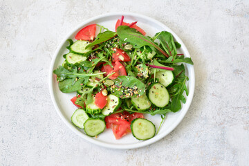 fresh vegetables with seeds and arugula on the plate top view 