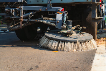 close-up of a street sweeper's cleaning mechanism. It features large circular brushes designed to...