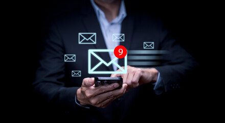 Naklejka premium Businessman hand pressing smartphone for sending the e-mail from the laptop computer, Email and SMS marketing concept. Scheme of direct sales in business. List of clients for mailing.