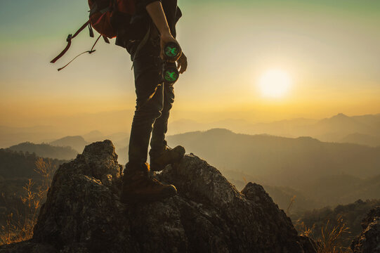 man is standing on a mountain top with a pair of binoculars in his hands