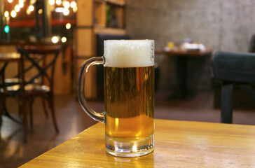 Glass of chilled draft beer Isolated on wooden table