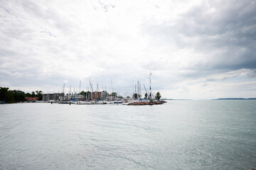 Fototapeta premium Scenic view of sailboats docked at a marina on a cloudy day in Siofok, Balaton lake, Hungary.