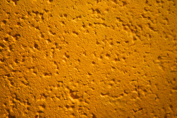 Close-up texture of an orange painted rough surface.