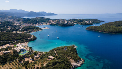 Fototapeta premium View from above, stunning aerial view of a bay with boats and luxury yachts sailing on a turquoise, clear water. Syvota, Greece.