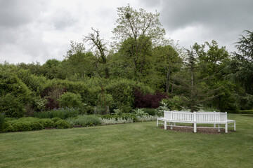 white wooden bench in an english country garden
