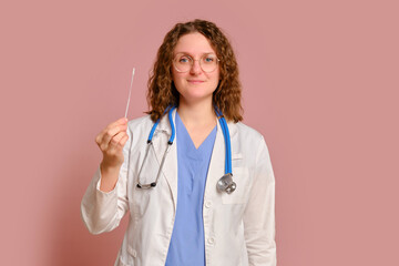 Woman doctor holding covid test stick, studio pink background. Nurse in uniform with stethoscope on red studio background