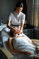 Obraz premium Face massage. Close-up of young woman getting spa massage treatment at beauty spa salon.