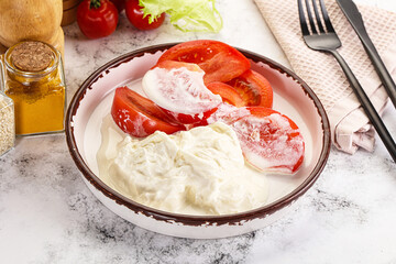 Salad with sliced tomato and stracciatella