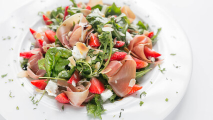  Salad with arugula, strawberries, meat, cheese.