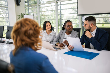 Human resource having a pleasant talk with a young female applicant in a relaxed atmosphere during an interview for a job.