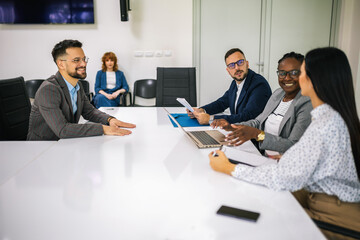 Human resource having a pleasant talk with a young male applicant in a relaxed atmosphere during an interview for a job.