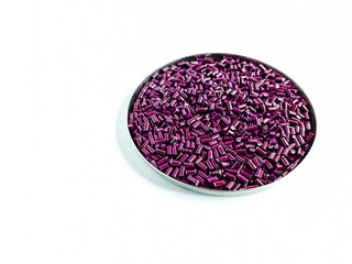 Rhubarb red masterbatch granules in a dish, isolated on white background.Color pigment carrier polymer in plastic industry