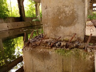Industrial background in the premises of an old production workshop with concrete structures and fittings sticking out of the concrete. An industrial building flooded with rainwater.