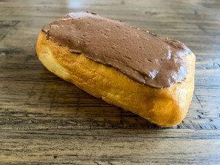 Closeup of cream filled, chocolate Long John donut