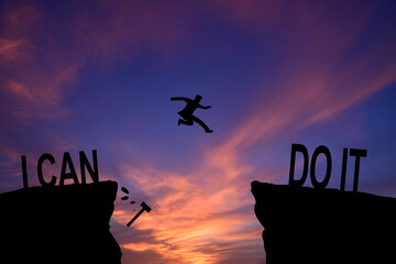 Man jumping on I can do it or I can't do it text over cliff on sunset background, Business concept...