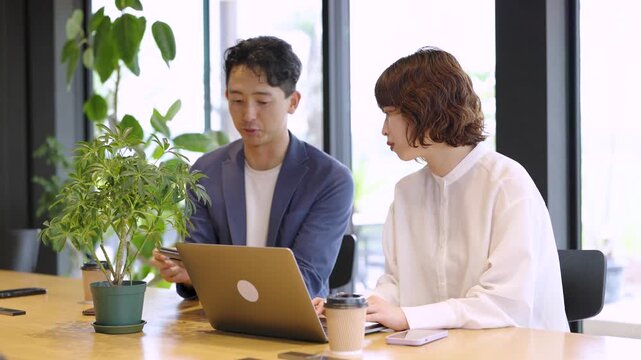 ノートパソコンを使ってミーティングをする男女の日本人ビジネスマン