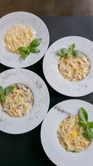 different types of pasta carbonara with cheese, salmon, mushrooms, egg, on a white plate on a black background