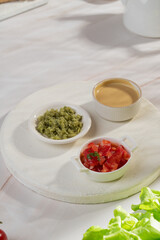 Red, yellow and green sauce in bowls on light background