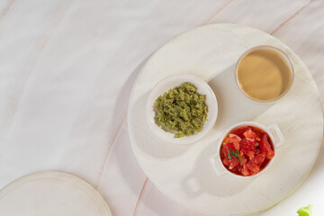 Red, yellow and green sauce in bowls on light background