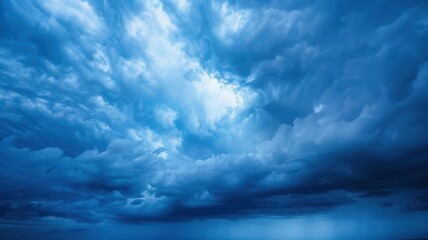 Obraz premium Dramatic storm clouds forming in a darkening blue sky, approaching storm, tension