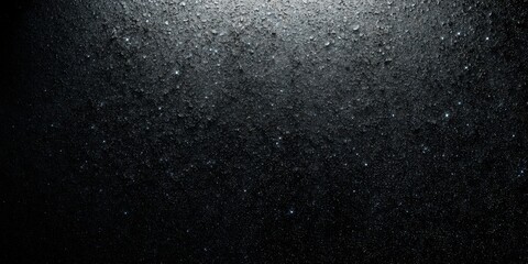 Obraz premium Raindrops glisten on a dark surface, reflecting light and creating texture