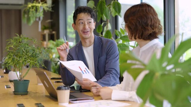 ノートパソコンを使ってミーティングをする男女の日本人ビジネスマン