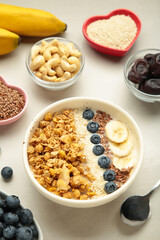Oat raisin granola with fresh summer berries in a bowl on light background. Space for text