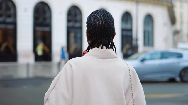 Black woman walking in the streets of paris and staring at the camera