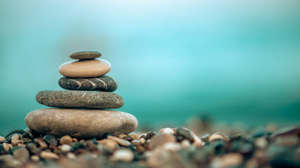A pyramid of stones on a pebble beach by the sea, the concept of balance, calm, tranquility, relaxation with copy space