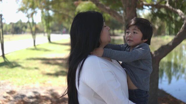 Mexican mother hugging her son at the park, mothers day concept 4k Video