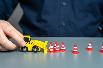 A man removes traffic cones with a bulldozer. The concept of lifting restrictions and prohibitions....