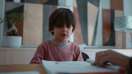 Child reluctant and struggling with learning, showing frustration and difficulty during a learning activity, highlighting the challenges of education in a supportive home environment