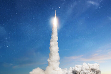 Space rocket lift off with starts a space mission in the blue sky. Spaceship with blast and smoke...