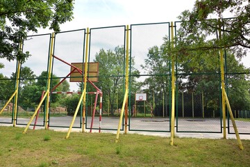 Old from the times 60s , 70S  and now , fenced dangerous concrete playground - football pitch and basketball