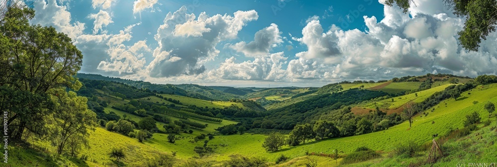 Wall mural This image showcases a stunning valley landscape with rolling green hills, lush vegetation, and a bright blue sky adorned with fluffy white clouds. The scene evokes a sense of peace, tranquility, and 