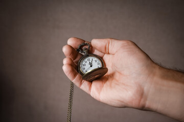 a pocket watch in the hands of a man