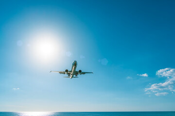 Airplane landing approach over sea beach. Travel by air transport