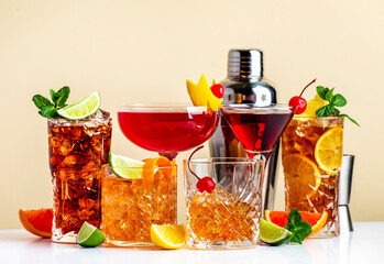 Summer cocktail drinks: long island ice tea, manhattan, cosmo, old fashioned and cuba libre. Beige background