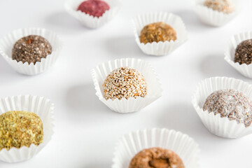 Box of healthy sweets, candies made from natural ingredients. Vegetarian organic food. White background, close-up