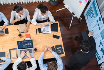 Obraz premium Wide top view of diverse group of business analyst team analyzing financial data report paper on meeting table. Chart and graph dashboard by business intelligence analysis. Meticulous