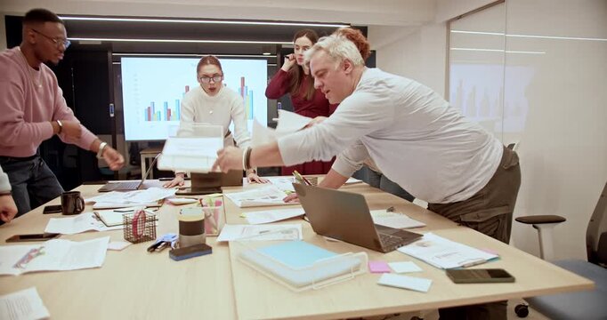 Cross generational, mixed race team of business professionals working collaboratively on a strategy for improved profitability and growth in a modern office setup.