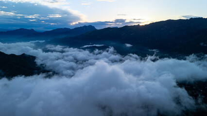 Majestic Sunrise Over Rolling Clouds in Mountainous Landscape Captured at Dawn