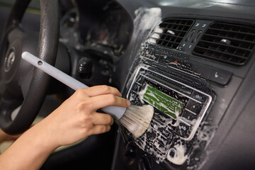 Car Interior Cleaning process underway with a brush for detailed professional detailing