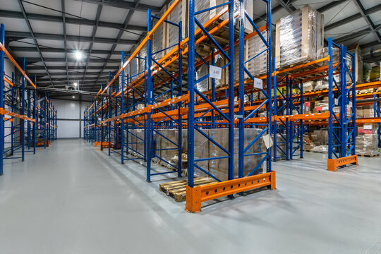 Industrial Warehouse Interior Featuring Organized Shelving Units and Inventory Storage.The interior of a spacious industrial warehouse showcases a systematic arrangement of shelving units. Tall racks 