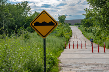 A road bump sign at the entrance of a public park