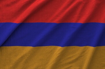 Armenia flag depicted on folded wavy fabric of old cloth close up