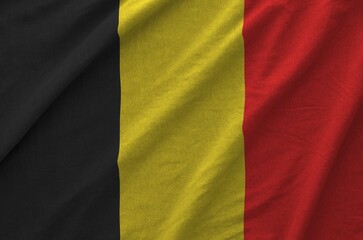 Belgium flag depicted on folded wavy fabric of old cloth close up