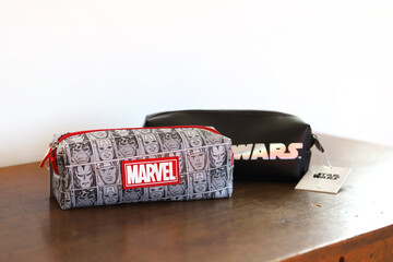 Naklejka premium School pencil case with Marvel superhero characters and Star Wars movie logo. School accessory. Isolated white. Background with copy space. 