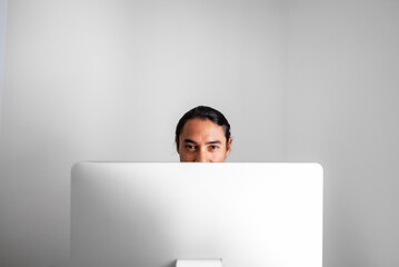 Portrait of a Latino man behind his computer. Copy space.