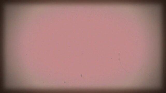 Vintage pink film background with vignette. Copy space on centre. Old retro film camera, textured background. Scratches, details and noise. Dusty and grainy feel. 4K motion graphics.